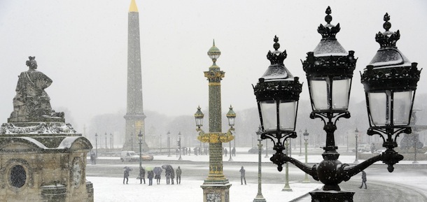 People walk under heavy snow falls on Place de la Concorde in Paris on March 12, 2013. More than 68,000 homes were without electricity in France and hundreds of people were trapped in their cars after a winter storm hit with heavy snow, officials and weather services said Tuesday. AFP PHOTO / BERTRAND GUAY (Photo credit should read BERTRAND GUAY/AFP/Getty Images)