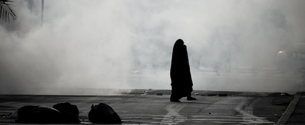 A Bahraini woman tries to run for cover from tear gas fired by riot police during an anti-government demonstration in the village of Sanabis, West of Manama, on March 14, 2013. Bahraini police clashed with youths protesting against the deployment into a third year of a Gulf military force that backed Manama's bid to crush a Shiite-led uprising, witnesses said. AFP PHOTO/MOHAMMED AL-SHAIKH (Photo credit should read MOHAMMED AL-SHAIKH/AFP/Getty Images)