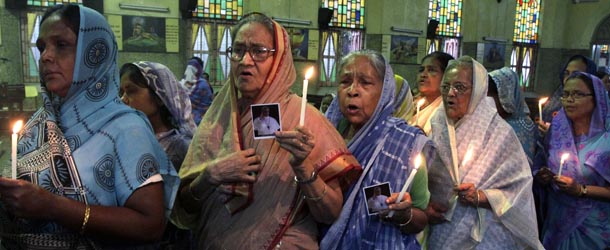 Elderly Indian Catholic women hold candles and photos of newly-elected Pope Francis during a thanksgiving mass at a church in Kolkata, India, Sunday, March 17, 2013. Argentine's former cardinal Jorge Mario Bergoglio was chosen as leader of the Catholic Church on March 13, 2013, making him the New World's first pope. (AP Photo/Bikas Das)