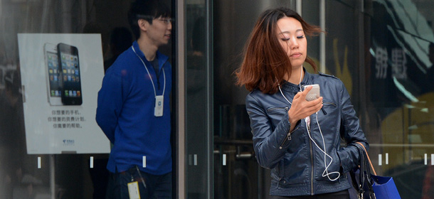 A customer leaves an Apple store on the busy Wangfujing shopping street in Beijing on March 29, 2013. China has ordered its consumer watchdogs to "strengthen supervision" of firms including Apple, as the US computer giant faces a barrage of negative publicity in the country. State media have carried a series of attacks against Apple, with the People's Daily, the Communist Party's official mouthpiece, running critical items for five consecutive days over alleged double standards in customer service and returns policies. AFP PHOTO/Mark RALSTON (Photo credit should read MARK RALSTON/AFP/Getty Images)