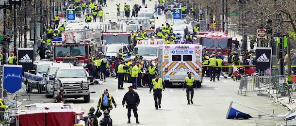 Police clear the area at the finish line of the 2013 Boston Marathon as medical workers help injured following explosions in Boston, Monday, April 15, 2013. The explosions near the finish of the Boston Marathon on Monday, killied at least two people, injuring over 20 others. (AP Photo/Charles Krupa)