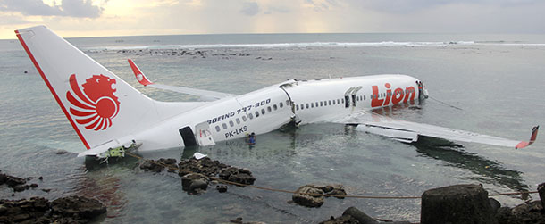 In this photo released by Indonesian Police, the wreckage of a crashed Lion Air plane sits on the water near the airport in Bali, Indonesia on Saturday, April 13, 2013. The plane carrying more than 100 passengers and crew overshot a runway on the Indonesian resort island of Bali on Saturday and crashed into the sea, injuring nearly two dozen people, officials said. (AP Photo/Indonesian Police)