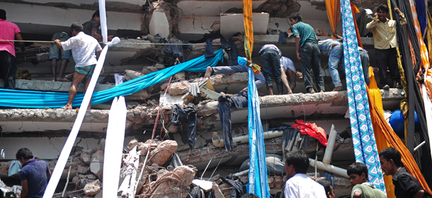 Bangladeshi volunteers prepare lengths of textiles to used as evacuation slides for the injured and dead after an eight-storey building collapsed in Savar, on the outskirts of Dhaka, on April 24, 2013. At least 60 people were killed and many more feared dead when an eight-storey building housing a market and garment factory collapsed in Bangladesh on Wednesday, an official said. AFP PHOTO/Munir uz ZAMAN (Photo credit should read MUNIR UZ ZAMAN/AFP/Getty Images)