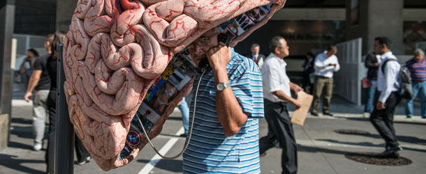 A man uses a public phone booth decorated as a brain in Sao Paulo, Brazil, on May 21, 2012. A hundred phone booths, nicknamed Orelhao (meaning "big ear" in Portuguese), are being replaced with art works by a local phone company. AFP PHOTO/Yasuyoshi CHIBA (Photo credit should read YASUYOSHI CHIBA/AFP/GettyImages)