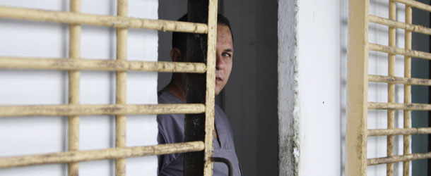 A prisoner looks at members of the press from his cell after the gate was opened by military guards at the Combinado del Este prison during a media tour of the prison in Havana, Cuba, Tuesday, April 9, 2013. Cuban authorities led foreign journalists through the maximum security prison, the largest in the Caribbean country that houses 3,000 prisoners. Cuba says they have 200 prisons across the country, including five that are maximum security. (AP Photo/Franklin Reyes)