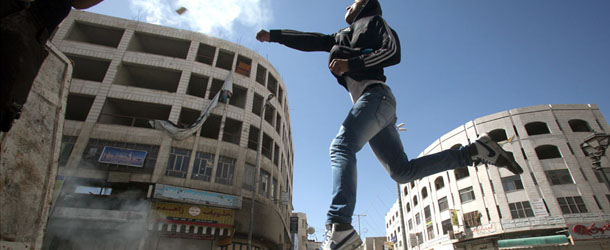 A Palestinian man throws a stone towards Israeli security during clashes in the West Bank city of Hebron following the death of a Palestinian prisoner on April 2, 2013. The Palestinian leadership blamed Israel for the death of Maisara Abu Hamdiyeh, a long-term prisoner with cancer, hiking tensions over a tinderbox issue closely followed on the Palestinian street. AFP PHOTO/HAZEM BADER (Photo credit should read HAZEM BADER/AFP/Getty Images)