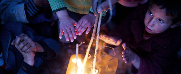 Syrian children warm themselves at a refugee camp near the Turkish border, in Azaz, Syria, Sunday, Dec. 9, 2012. Temperatures dropped to 9 degrees Celsius (48 degrees Fahrenheit) in Azaz. (AP Photo/Manu Brabo)