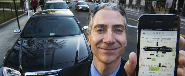 Peter Faris, CEO of Szabo Faris LLC Transportation Solutions, stands in front of one of his vehicles while holding a smart phone with an app that orders up his sedan service February 14, 2013 in Washington, DC. Faris, an independent driver who works with Uber, a technology firm which has created a mobile app which allows consumers to use their device to request a nearby taxi or limousine. Uber is among a number of apps which are being deployed in cities in the United States and worldwide. AFP Photo/Paul J. Richards (Photo credit should read PAUL J. RICHARDS/AFP/Getty Images)