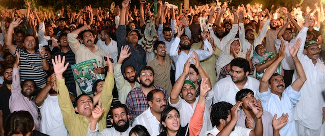 Supporters of former Pakistani Prime Minister and head of the Pakistan Muslim League-N (PML-N) Nawaz Sharif, cheer as they listen to Sharif outside his residence after his party victory in general election in Lahore on May 11, 2013. Sharif declared victory for his centre-right party in Pakistan's landmark elections on May 11, as unofficial partial results put him on course to win a historic third term as premier. The result represented a remarkable comeback for a man who was deposed as premier in a 1999 military coup and came after millions of people defied polling day attacks that left 24 dead to participate in the high-turnout vote. AFP PHOTO / ARIF ALI (Photo credit should read Arif Ali/AFP/Getty Images)