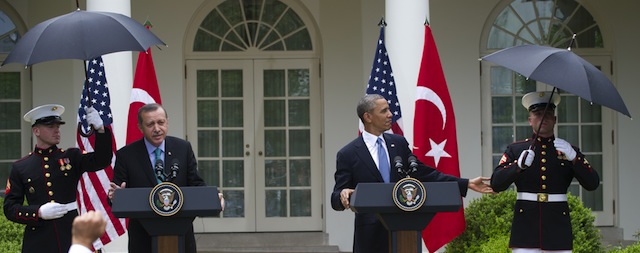 US President Barack Obama tells a US Marine that they no longer need umbrellas as it has stopped raining alongside Turkish Prime Minister Recep Erdogan during a joint press conference in the Rose Garden of the White House in Washington, DC, May 16, 2013. AFP PHOTO / Saul LOEB (Photo credit should read SAUL LOEB/AFP/Getty Images)