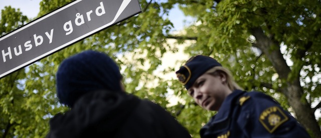 A policewoman speaks with a resident of Husby during a demonstration against police violence and vandalism in the Stockholm suburb of Husby on May 22, 2013. Rioting spread across Stockholm immigrant districts in a third night of unrest, raising fears that decades of integration efforts have gone dangerously awry. The riots are believed to have been sparked by the deadly police shooting last week of an elderly man in Husby -- a run down, low-income suburb that is only a short walk away from the Kista Science Tower skyscraper, a symbol of the booming IT sector in one of Europe's wealthiest cities. AFP PHOTO / JONATHAN NACKSTRAND