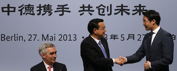 Chinese Premier Li Keqiang (C) shakes hands with German Economy Minister Philipp Roesler (R) as Chairman of the Asian-Pacific Committee of German Business (APA) Peter Loescher looks on during their meeing in Berlin on May 27, 2013. The German sentence in the background reads: Germany - China, Structuring the Future Together. AFP PHOTO /Tobias Schwarz/POOL (Photo credit should read TOBIAS SCHWARZ/AFP/Getty Images)
