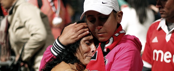 Benfica supporters comfort each other as they watch in a giant screen at Lisbon's Comercio square the Europa League final soccer match between Benfica and Chelsea being played at the ArenA stadium in Amsterdam, Wednesday, May 15, 2013. Chelsea defeated Benfica 2-1. (AP Photo/Francisco Seco)
