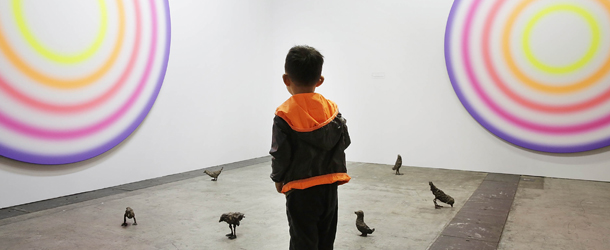 HONG KONG - MAY 22: A little boy looks at art works on the floor and wall by Ugo Rondinone, which are represented by gallery Galerie Eva Presenhuber at Art Basel, May 22, 2013 in Hong Kong. (Photo by Jessica Hromas/Getty Images)