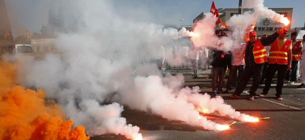 Employees of Arkema Kem One chemical company and employees of other petrochemical sites, burn flares as they block the Arkema plant in Marseille, southern France, Tuesday, May 14 , 2013. Kem One, the maker of vinyl products announced last July it may cuts jobs. (AP Photo/Claude Paris)