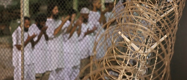 FILE - In this May 14, 2009, file photo, reviewed by the U.S. military, Guantanamo detainees pray before dawn near a fence of razor-wire, inside Camp 4 detention facility at Guantanamo Bay U.S. Naval Base, Cuba. The Democratic-controlled Senate resoundingly barred Wednesday, May 20, 2009, a shutdown of the Guantanamo prison and blocked the transfer of terror detainees to the United States, a major setback for President Barack Obama, who has promised to close the prison. (AP Photo/Brennan Linsley)