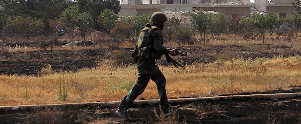 EXCLUSIVE AFP
A Syrian army soldier runs during a battle against opposition fighters in the city of Qusayr, in Syria's central Homs province, on May 23, 2013. Syrian government troops launched a week ago an assault on Qusayr and the intervention of hundreds of fighters of Shiite militant group Hezbollah from neighbouring Lebanon has given the regime the upper hand in the battle. AFP PHOTO/STR == LEBANON OUT== (Photo credit should read STR/AFP/Getty Images)