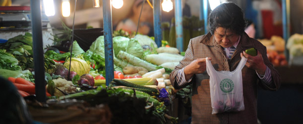 An elderly woman looks at vegetables she just brought in a market in Shanghai on May 9, 2013. Inflation in China accelerated to 2.4 percent year-on-year in April official data showed, above market expectations but analysts said counter-measures were unlikely due to weak economic momentum. AFP PHOTO/Peter PARKS (Photo credit should read PETER PARKS/AFP/Getty Images)