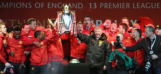 Retiring iconic Manchester United manager Alex Ferguson (C) and his players hold the Premier League trophy outside the town hall in Manchester, north west England, on May 13, 2013 during the team's victory parade to celebrate winning the Premier League for the 13th time. AFP PHOTO/ANDREW YATES (Photo credit should read ANDREW YATES/AFP/Getty Images)