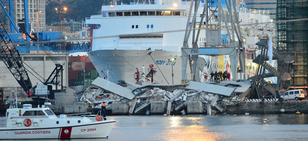 Rescue workers inspect the scene near a damaged control tower (C) in the port of Genoa early on May 8, 2013, after a container ship smashed into the tower leaving at least three people dead and several missing in a night-time accident. The accident, which took place at around half past midnight (2230 GMT, May 7), spooked Italians still reeling from the Costa Concordia night-time shipwreck off Giglio island in January 2012 which left 32 people dead. AFP PHOTO / GIUSEPPE CACACE (Photo credit should read GIUSEPPE CACACE/AFP/Getty Images)