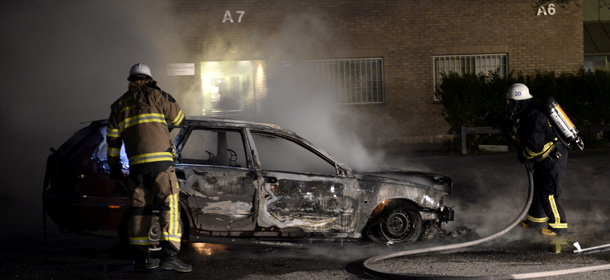 Firemen extinguish a burning car in Kista after youths rioted in few differant suburbs around Stockholm on May 21, 2013. Youths in the immigrant-heavy Stockholm suburb of Husby torched cars and threw rocks at police, in riots believed to be linked to the deadly police shooting of a local resident. AFP PHOTO/JONATHAN NACKSTRAND (Photo credit should read JONATHAN NACKSTRAND/AFP/Getty Images)