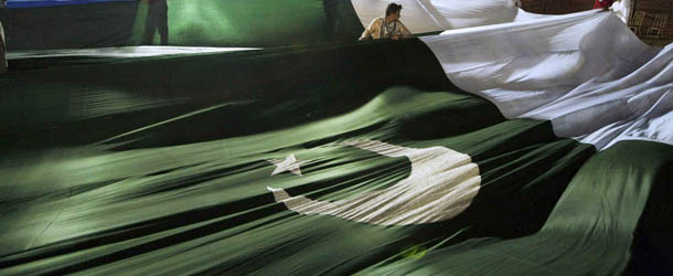 Supporters of Jamaat-e-Islami display a huge national flag at an election campaign rally in Karachi, Pakistan, Sunday, May 05, 2013. Pakistan is scheduled to hold parliamentary elections on May 11, the first transition between democratically elected governments in a country that has experienced three military coups and constant political instability since its creation in 1947. (AP Photo/Fareed Khan)