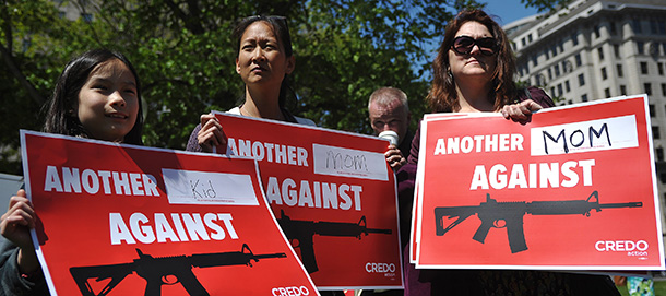 Protesters hold placards during a demonstration calling for tighter gun control on April 25, 2013 in McPherson Square in Washington, DC. AFP PHOTO/Mandel NGAN (Photo credit should read MANDEL NGAN/AFP/Getty Images)