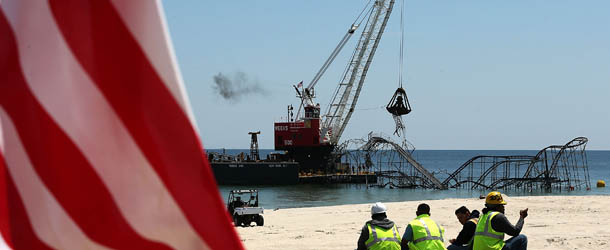 SEASIDE HEIGHTS, NJ - MAY 14: Workers on lunch break watch removal of the Star Jet roller coaster that has been in the ocean for six months after the Casino Pier is sat on collapsed when Superstorm Sandy hit, May 14, 2013 in Seaside Heights, New Jersey. The Casino Pier has contracted Weeks Marine to remove the Jet Star roller coaster from the Atlantic Ocean. (Photo by Mark Wilson/Getty Images)