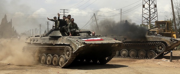 AFP EXCLUSIVE
Syrian troops celebrate as they take control of the village of Western Dumayna, some seven kilometers north of the rebel-held city of Qusayr, on May 13, 2013. Syrian troops captured three villages in the strategic Qusayr area of Homs province, allowing them to cut supply lines to rebels inside Qusayr town, a military officer told AFP. AFP PHOTO/JOSEPH EID (Photo credit should read JOSEPH EID/AFP/Getty Images)