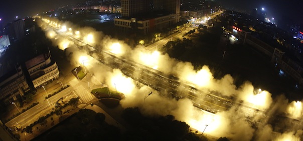 In this photograph taken on May 19, 2013, explosives go off as Dunyang highway viaduct collapses during a controlled demolition in Wuhan, central China's Hubei province. With 100,000 volt wiring running alongside the viaduct and 30 major gas pipelines underneath it, explosives experts were faced with a task requiring particular precision. The two mile long viaduct was the longest concrete bridge ever demolished in China, local media reported. CHINA OUT AFP PHOTO (Photo credit should read STR/AFP/Getty Images)