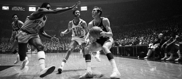 Jerry West of the Los Angeles Lakers crashes against Willis Reed of the New York Knicks as he passes off to Wilt Chamberlain in the opening minutes of the first game of the NBA Championship playoff series in Inglewood, Cal., Tuesday, May 1, 1973. Chamberlain was fouled a moment later but missed the free throw. (AP Photo/Jeff Robbins)