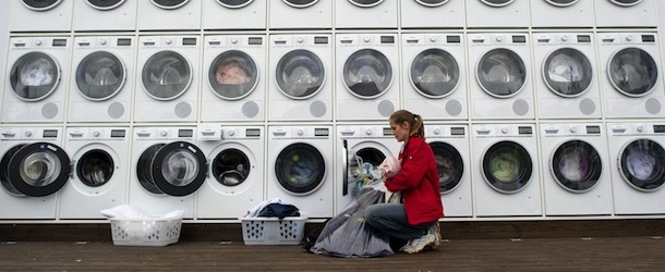 People do their laundry at a wall of washing machines and dryers at a city beach near the main station in Berlin on September 7, 2011. The German home appliance firm Siemens hosts until September 10, 2011 the free wash and dry service for tourists and local residents as promotional event during the IFA consumer electronics fair running until September 7, 2011. AFP PHOTO / ODD ANDERSEN (Photo credit should read ODD ANDERSEN/AFP/Getty Images)