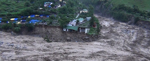 Houses perch precariously as river banks collapse from the rising waters of the flooded river in the northern state of Uttarakhand on June 17, 2013. Heavy rains lashed parts of north India June 17, resulting in the deaths of at least 26 people, as the annual monsoon covered the country nearly two weeks ahead of schedule, officials said. AFP PHOTO (Photo credit should read STR/AFP/Getty Images)