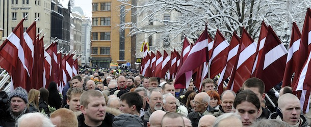 With Latvian flags, people march in a procession to the Freedom Monument to honor soldiers of Waffen SS unit known as the Latvian Legion, which fought on the side of Nazi Germany during World War II, in the downtown Riga, Latvia, Tuesday, March 16, 2010. Latvians who take part in the annual procession claim they want to commemorate compatriots killed in the war, while ethnic Russian protesters accuse them of whitewashing history and having Nazi sympathies. (AP Photo / Roman Koksarov)