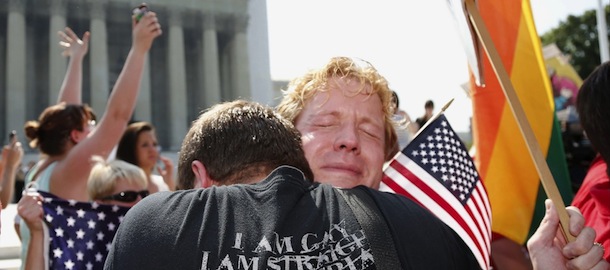 Michael Knaapen, left, and his husband John Becker, right, embrace outside the Supreme Court in Washington, Wednesday, June 26, 2013 after the court struck down a federal provision denying benefits to legally married gay couples. (AP Photo/Charles Dharapak)