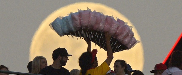 A cotton candy vendor, center, walks in from of the moon during the Los Angeles Angels' baseball game against the Pittsburgh Pirates, Saturday, June 22, 2013, in Anaheim, Calif. (AP Photo/Mark J. Terrill)