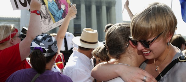 American University students Sharon Burk, left, and Molly Wagner, embrace outside the Supreme Court in Washington, Wednesday, June 26, 2013, after the court cleared the way for same-sex marriage in California by holding that defenders of California's gay marriage ban did not have the right to appeal lower court rulings striking down the ban. (AP Photo/Charles Dharapak)