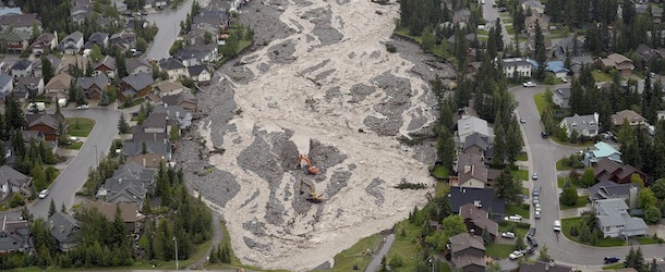 In this aerial photo, the flooded Cougar Creek runs through Canmore, Alberta, on Friday June 21, 2013. Communities throughout southern Alberta are dealing with overflowing rivers that have washed out roads and bridges, inundated homes and turned streets into dirt-brown tributaries. (AP Photo/The Canadian Press, Jonathan Hayward)