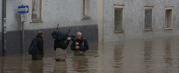 A TV crew films in the flooded old town of Passau, southern Germany, on Tuesday, June 4, 2013. Floodwaters in Passau are receding from the highest level seen in more than five centuries but cities downstream are bracing themselves as swollen rivers sweep through southeastern Germany. At least eight people have been reported dead and nine missing in the floods in Germany, Austria, Switzerland and the Czech Republic. (AP Photo/Matthias Schrader)
