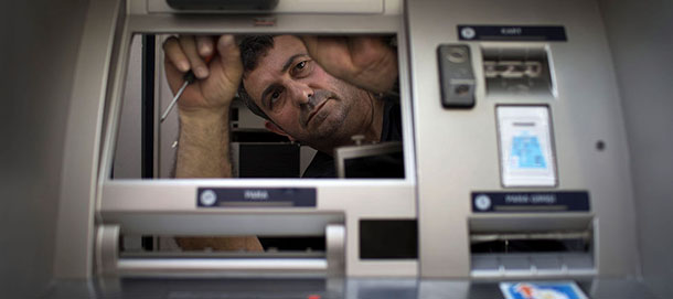 ISTANBUL, TURKEY - JUNE 05: Technicians fix ATM machines that were damaged during riots after anti-government demonstrations on June 5, 2013 in Istanbul, Turkey. The protests began initially over the fate of Taksim Gezi Park, one of the last significant green spaces in the center of the city. The heavy-handed viewed response of the police, Prime Minister Recep Tayyip Erdogan and his government's increasingly authoritarian agenda has broadened the rage of the clashes. (Photo by Uriel Sinai/Getty Images)