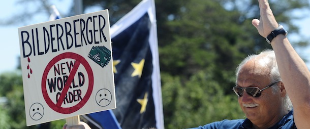 An activist protests near the meeting place for the conference of the Bilderberg Group meeting in Sitges, Spain, Thursday, June 3, 2010. The Bilderberg Group is an unofficial conference of around 130 invitation-only guests who are insiders in politics, banking, business, military and the media. The group's meetings are held in secret and are closed to the public. (AP Photo/Manu Fernandez)