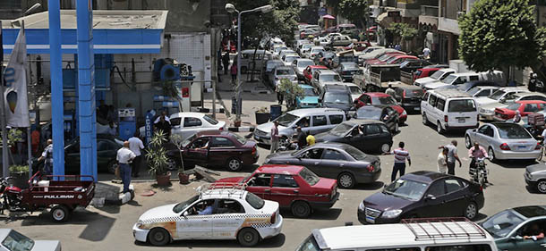 Egyptian drivers wait in long queues outside a gasoline station, in Cairo, Egypt, Wednesday, June 26, 2013. Fuel shortages have caused long lines for months, but Egypt's Supply Minister Bassem Ouda told a news conference that the latest fuel shortage will end in a matter of days. Authorities blame the shortage on a technical problem at a major petrol depot on the outskirts of Cairo. (AP Photo/Hassan Ammar)