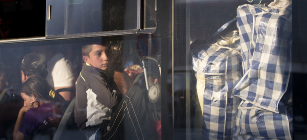 Romanian Roma people expelled from France ride on a crowded bus at Bucharest's Henri Coanda international airport in Otopeni, Romania, Thursday, Sept. 13, 2012. French Interior Minister Manual Valls,on a two-day official visit to Romania, discuss with Romanian authorities the issue of Roma immigration to France and ways to support Roma inclusion. (AP Photo/Vadim Ghirda)