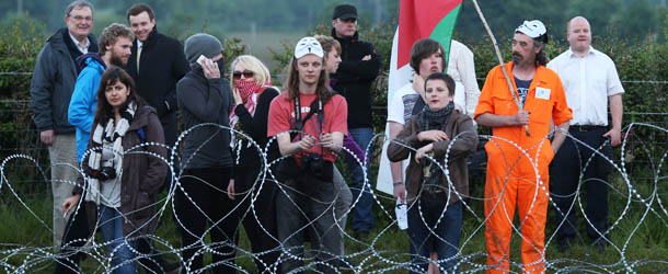 ENNISKILLEN, NORTHERN IRELAND - JUNE 17: Anti-G8 protester stand at the outer perimeter razor wire fence around the G8 summit venue at Lough Erne on June 17, 2013 in Enniskillen, Northern Ireland. The two day G8 summit, hosted by UK Prime Minister David Cameron, is being held in Northern Ireland for the first time. Leaders from the G8 nations have gathered to discuss numerous topics with the situation in Syria expected to dominate the talks. (Photo by Peter Macdiarmid/Getty Images)