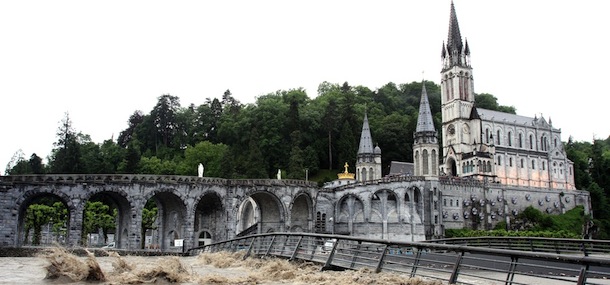 The Gave de Pau, the river passing through Lourdes, southwestern France, floods in front of Notre-Dame-du-Rosaire (the Rosary Basilica) on June 18, 2013. French authorities today shut the grotto at Lourdes and evacuated about 200 people following flash floods at the Roman Catholic pilgrimage site. AFP PHOTO LAURENT DARD