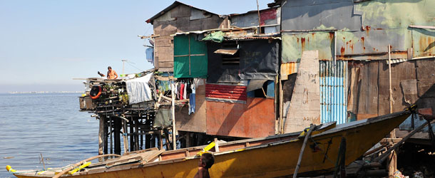MANILA, PHILIPPINES - MAY 29: A child sits on a bamboo stilt holding a fishing boat along the coast of Navotas City on May 29, 2013 in Manila, Philippines. It has been reported that 105,000 of 580,000 informal settlers in Manila have set up home in disaster prone areas. Recent reports have named the Philippines as Asia's fastest growing economy, however the housing shortage is still a major concern for many of Manila's poorest communities. (Photo by Veejay Villafranca/Getty Images)