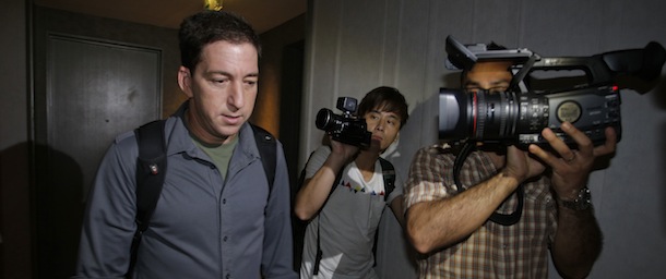 Glenn Greenwald, left, a reporter for The Guardian newspaper, walks out from his hotel room in Hong Kong Monday, June 10, 2013. Greenwald reported a 29-year-old contractor who claims to have worked at the National Security Agency and the CIA allowed himself to be revealed Sunday as the source of disclosures about the U.S. government's secret surveillance programs, risking prosecution by the U.S. government. (AP Photo/Vincent Yu)