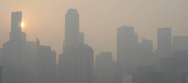 The sun rises over the Singapore Central Business District, or CBD skyline as the haze or smog envelopes the city on Thursday, June 20, 2013. A smoky haze triggered by forest fires in neighboring Indonesia has caused air pollution to briefly hit its worst level in nearly 16 years in Singapore. (AP Photo/Joseph Nair)