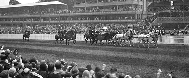 Britain's King George V and Queen Mary are driven down the course in an open carriage before the start of racing at Ascot Race Course, England, on June 17, 1930. (AP Photo/Staff/Putnam)