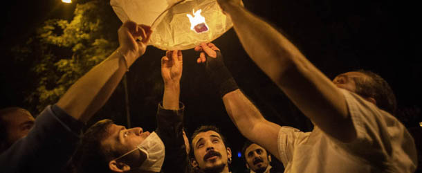 Turkish protesters light a lantern during riots in a restaurant district of Ankara June 5, 2013. Thousands of striking workers took to the streets of Turkey's cities today, loudly joining calls for Prime Minister Recep Tayyip Erdogan to step down as mass protests against his rule intensified. Bellowing to the din of drums and wailing Turkish pipes, teachers, doctors, bank staff and others marched in a sea of red and yellow labour union flags in the capital Ankara and in Istanbul, where they converged on Taksim Square, the cradle of nearly a week of violent clashes. AFP PHOTO / MARCO LONGARI (Photo credit should read MARCO LONGARI/AFP/Getty Images)